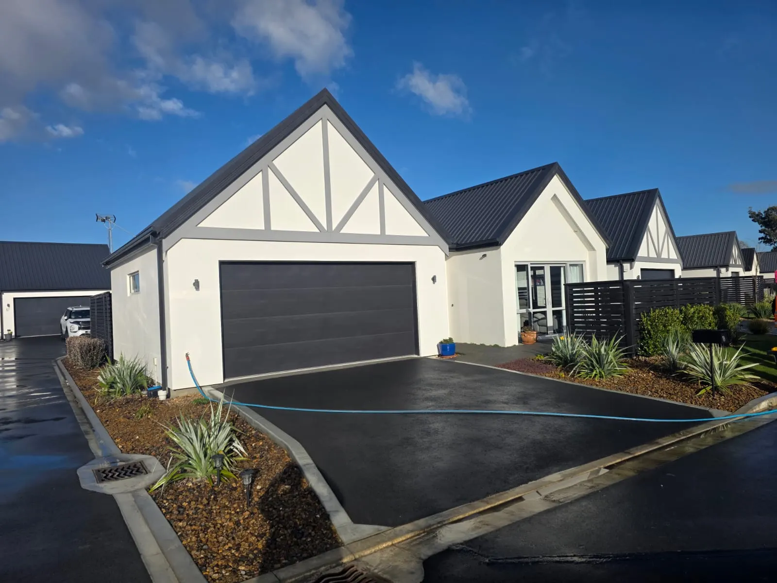 Finished gable-front homes with white plaster and dark accents