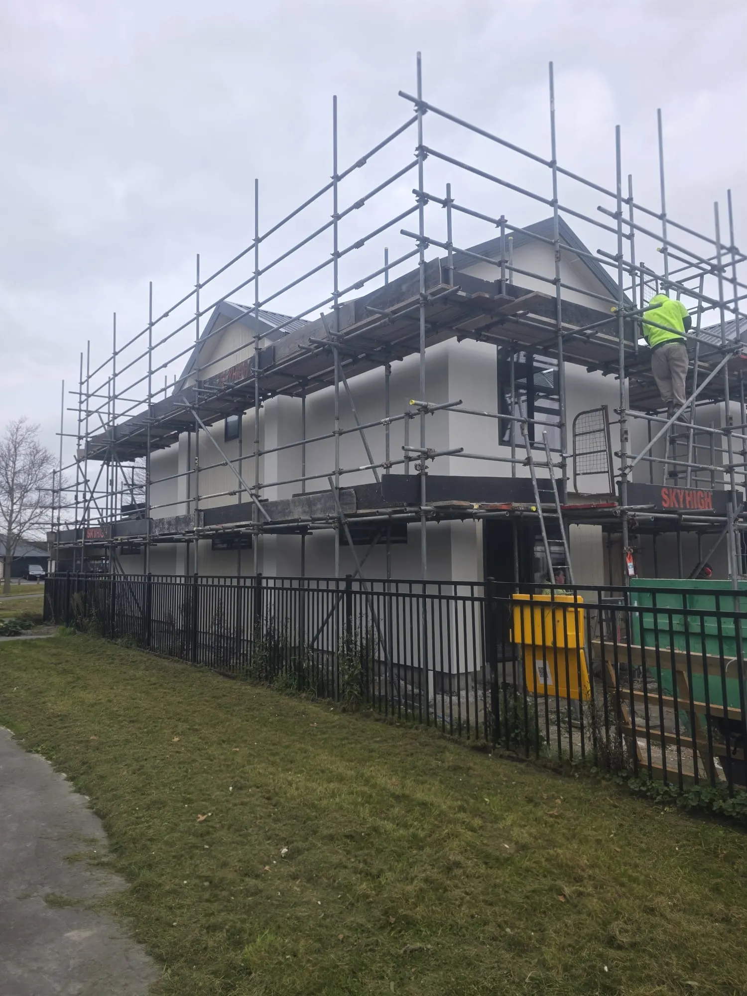 Two-storey homes under scaffolding during exterior plastering